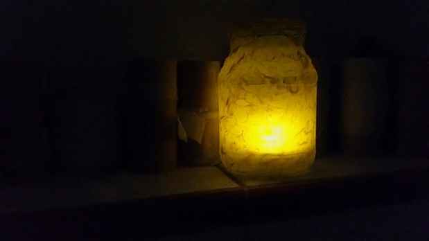 Gelbes Glas mit LED-Teelicht - zwischen einer Sammlung von Klopapierrollen zum Basteln XD